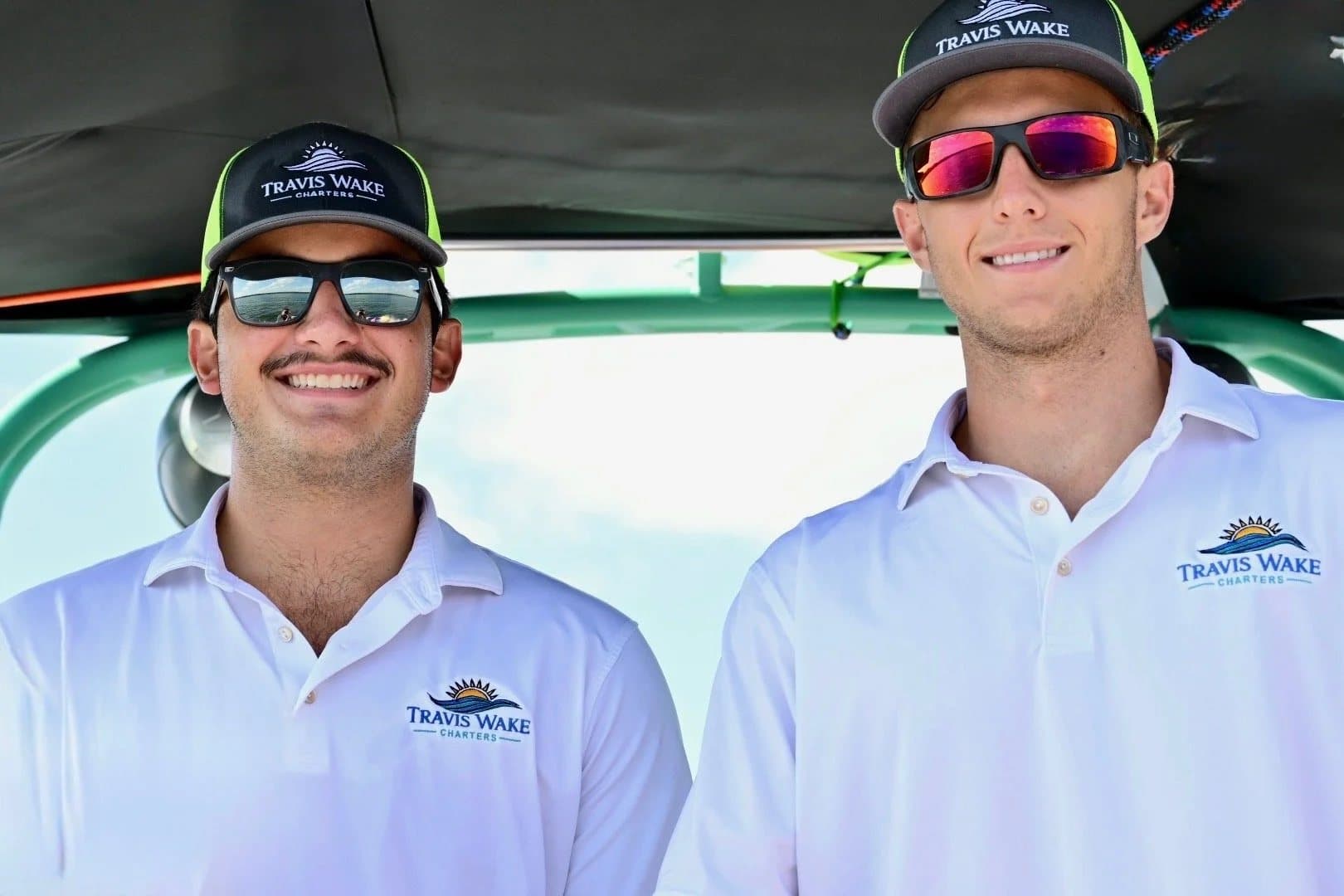 Joe and Jacob in Travis Wake Charters polos at the helm.