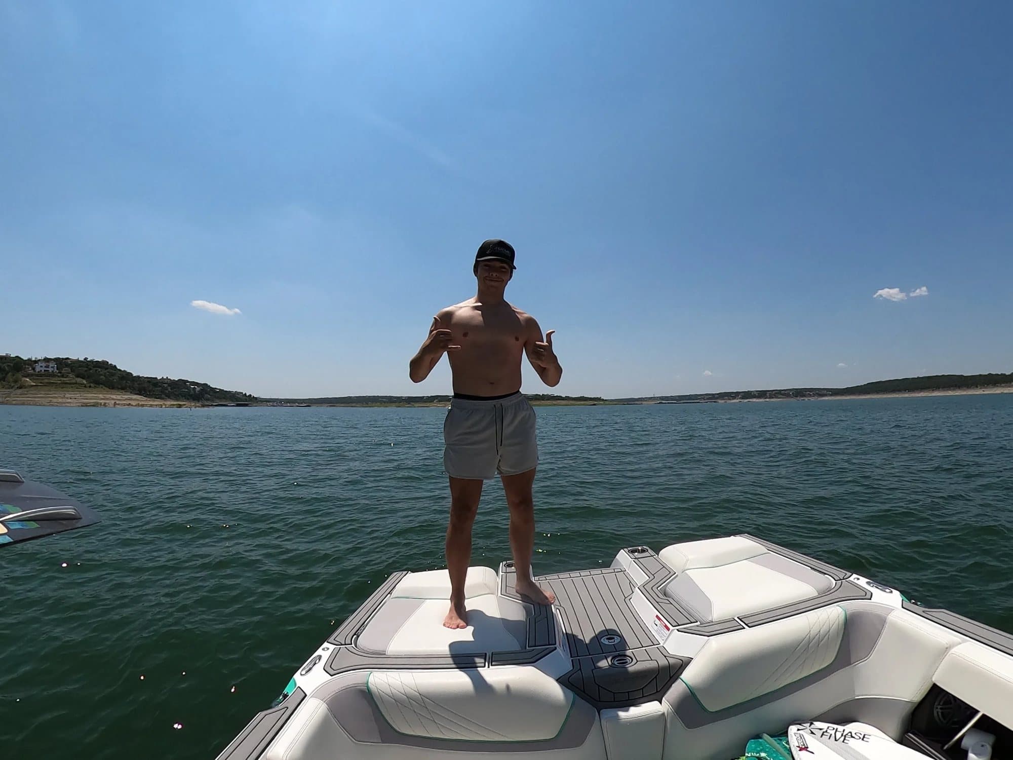 Joe on the bow of the Nautique, Lake Travis behind him.